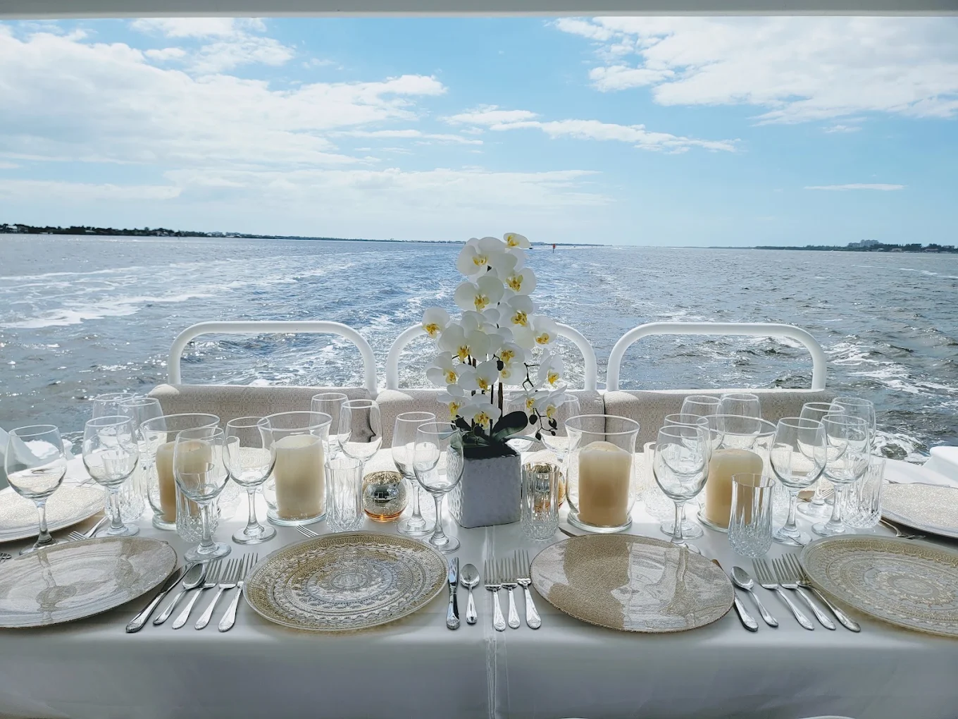 Elegant yacht-side dining table with orchids overlooking the water