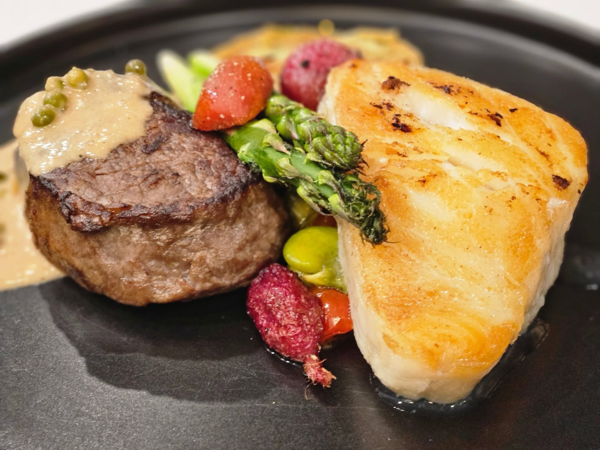 Seared filet mignon and pan-seared white fish with heirloom vegetables